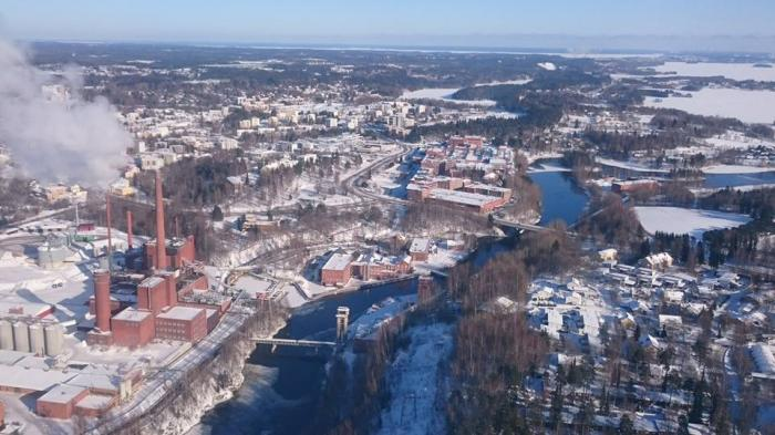 Flygbild över staden Nokia i Finland med industriområde och älv vintertid